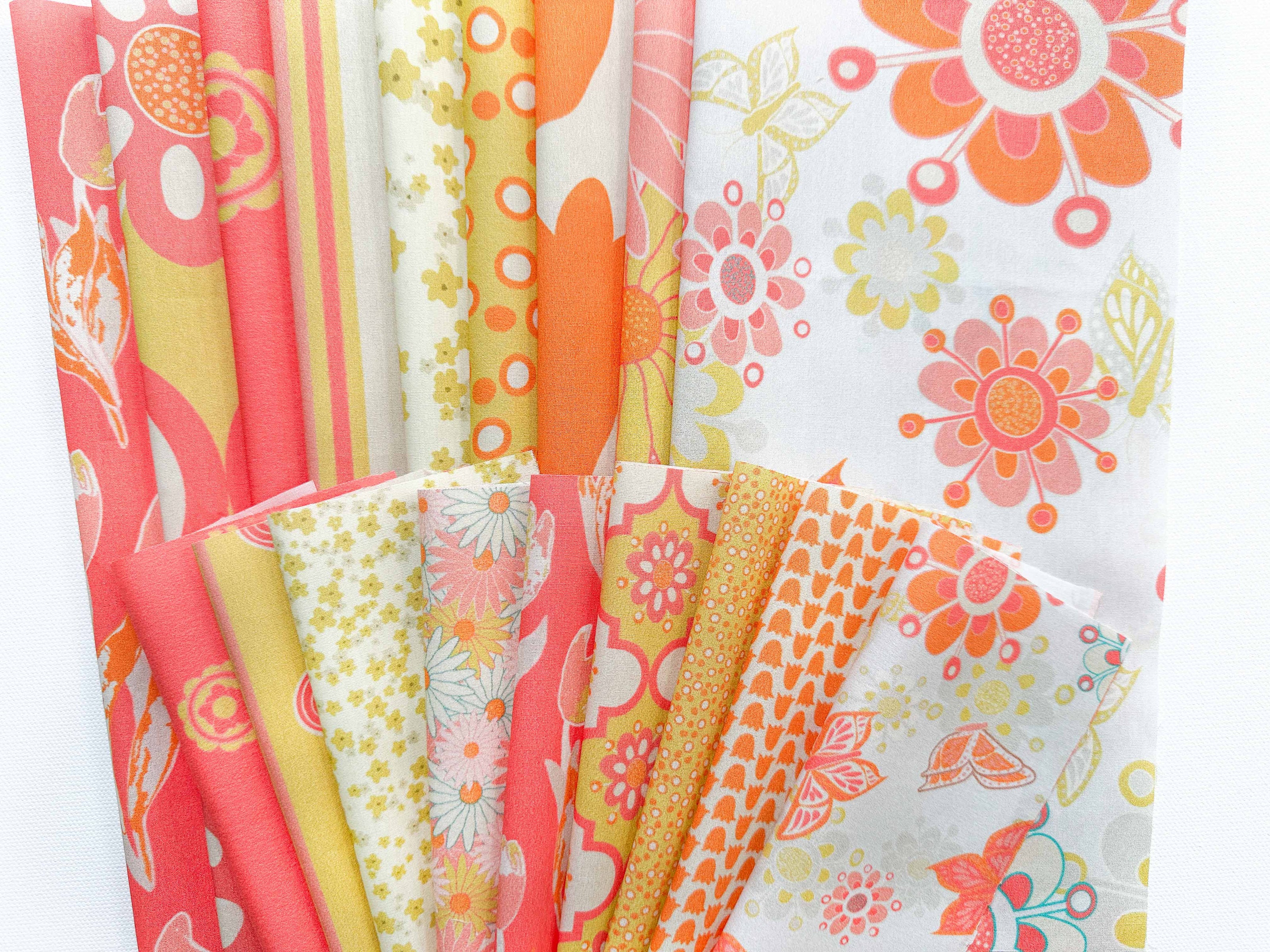 Patterns from the Buds, Blossoms, and Wings collection in varied scales. Colors are orange, pink, gold and cream